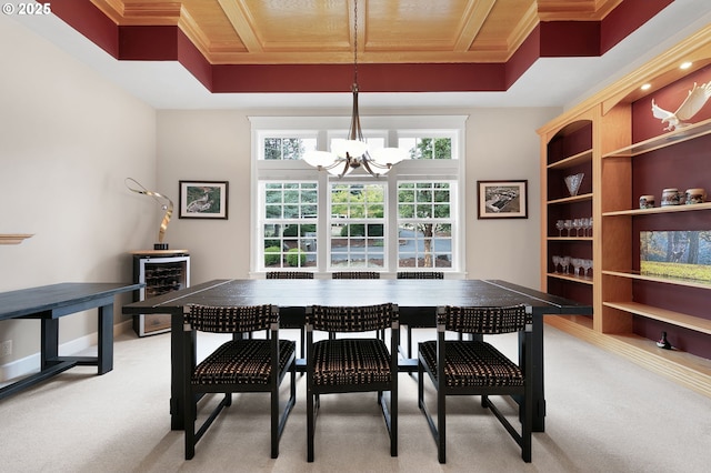 dining room featuring beverage cooler, a chandelier, light carpet, and crown molding