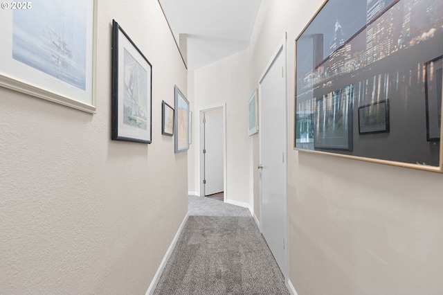 hallway featuring carpet floors and baseboards