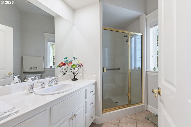 bathroom featuring tile patterned floors, baseboards, a stall shower, and vanity