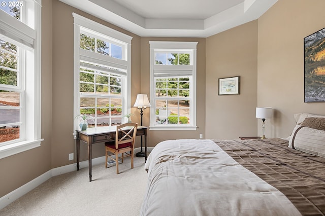 carpeted bedroom featuring multiple windows and baseboards