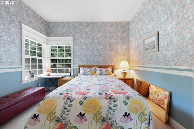 bedroom featuring wallpapered walls, carpet floors, and a wainscoted wall