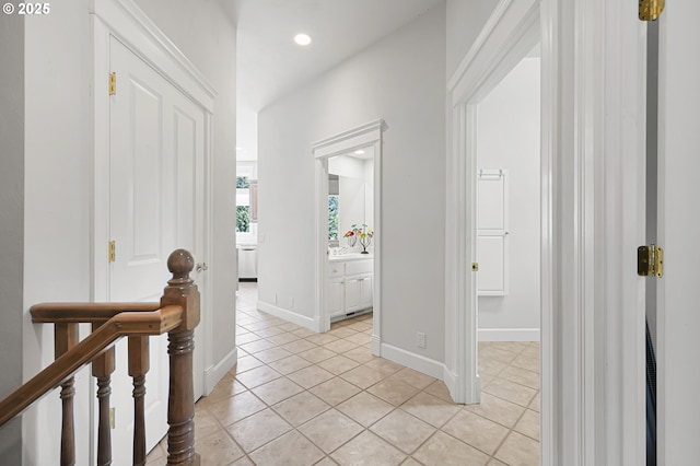 hallway with light tile patterned flooring, recessed lighting, baseboards, and an upstairs landing