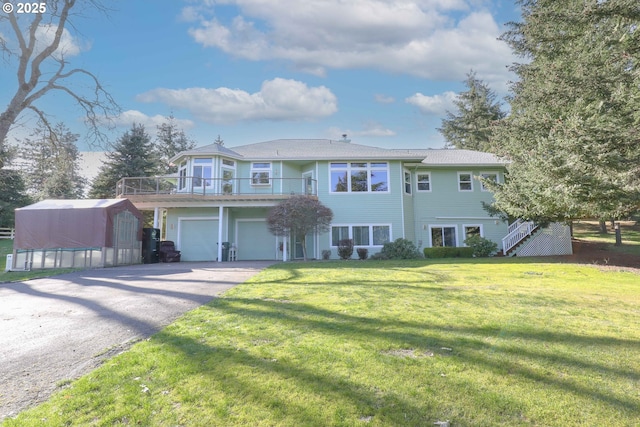 view of front of house featuring a front yard, stairway, an outbuilding, driveway, and a garage