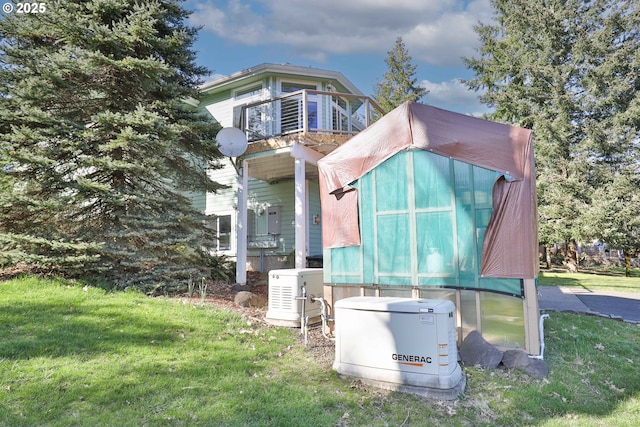 view of property exterior featuring a balcony and a yard