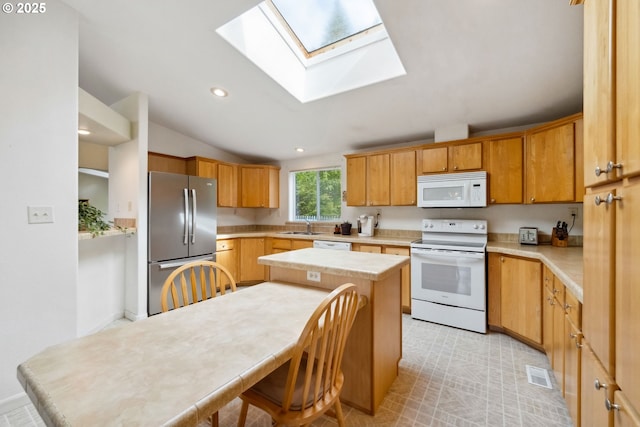 68226 Iris Rd, North Bend, OR 97459 - kitchen featuring white appliances, light countertops, a skylight, recessed lighting, and a sink