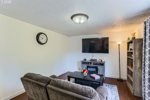 living room with dark hardwood / wood-style floors and a textured ceiling