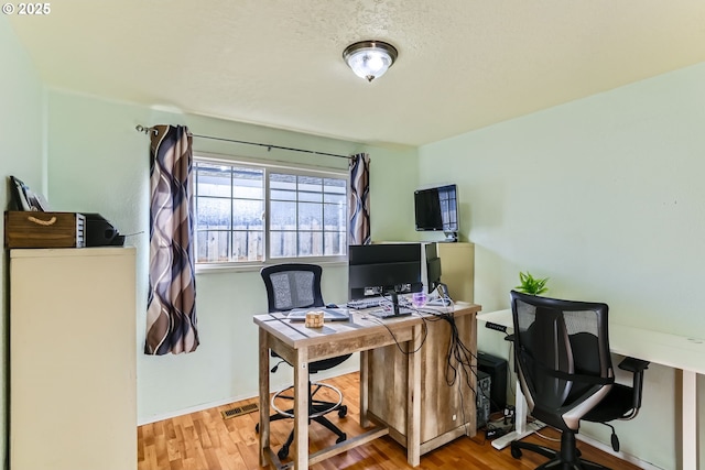 office featuring wood-type flooring and a textured ceiling