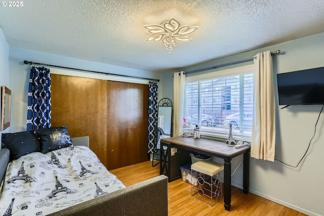 bedroom featuring hardwood / wood-style flooring and a textured ceiling