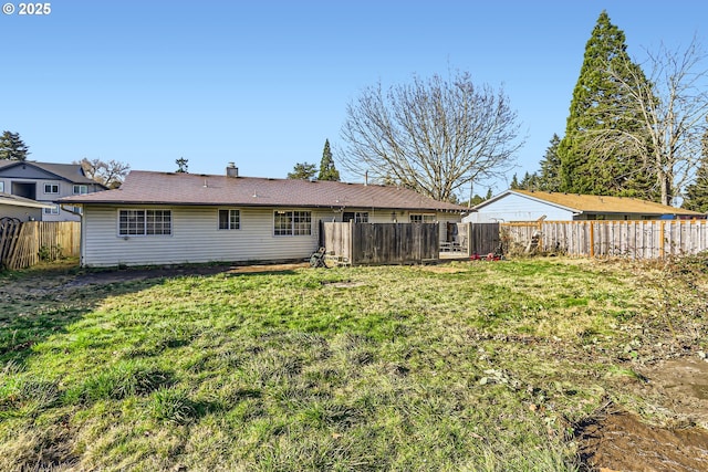 rear view of property featuring a lawn