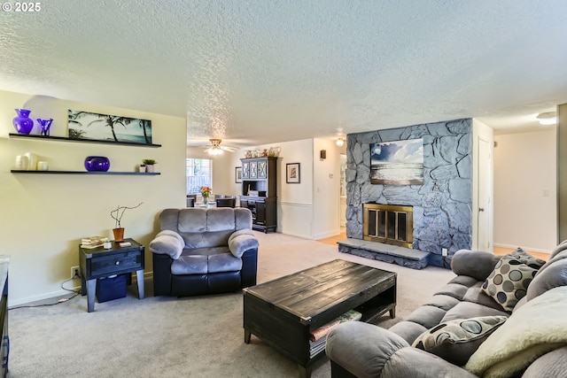 living room featuring carpet floors, ceiling fan, a textured ceiling, and a stone fireplace