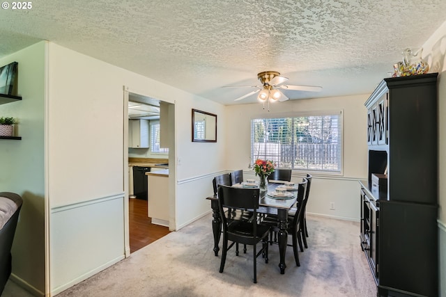 carpeted dining room featuring ceiling fan and a textured ceiling