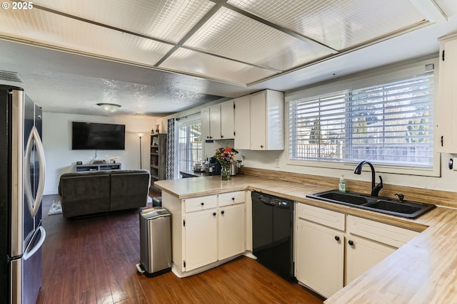 kitchen with black dishwasher, white cabinetry, stainless steel refrigerator, sink, and kitchen peninsula