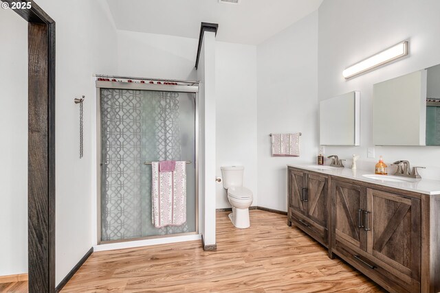 250 Valley View Rd, Sutherlin, OR 97479 - bathroom with wood finished floors, toilet, a stall shower, double vanity, and baseboards