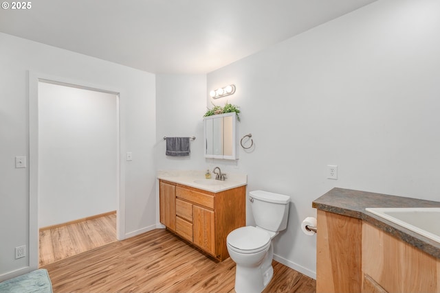 250 Valley View Rd, Sutherlin, OR 97479 - bathroom with wood finished floors, vanity, toilet, and baseboards