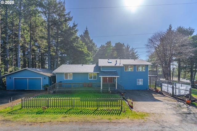 view of front of house featuring a garage, a fenced front yard, an outbuilding, and a front yard