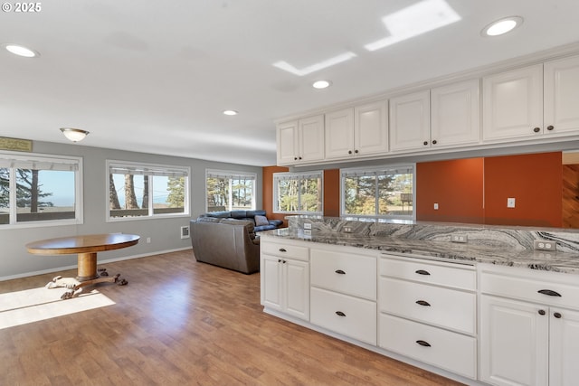 kitchen featuring light wood-type flooring, light stone counters, and recessed lighting