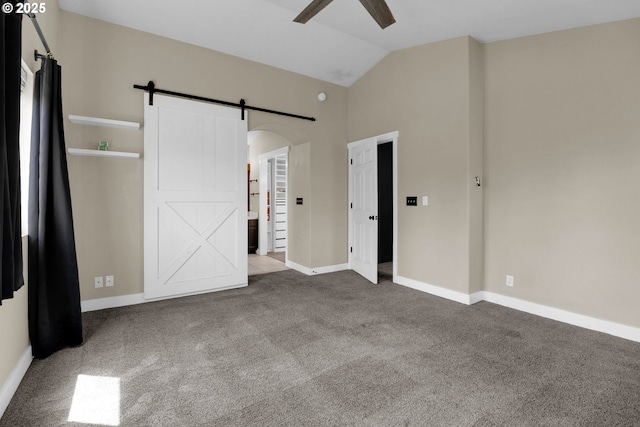 5416 Wales Dr, Eugene, OR 97402 - unfurnished bedroom with a barn door, carpet flooring, lofted ceiling, arched walkways, and ceiling fan