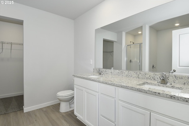 bathroom featuring walk in shower, vanity, toilet, and hardwood / wood-style floors