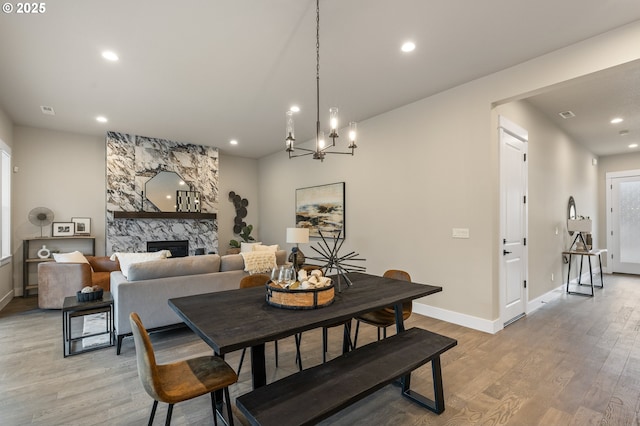 dining space featuring a fireplace and light hardwood / wood-style flooring