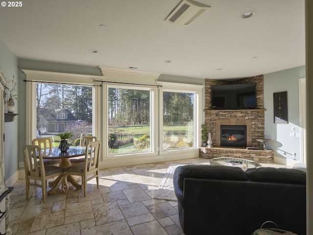 living room with a stone fireplace and a wealth of natural light