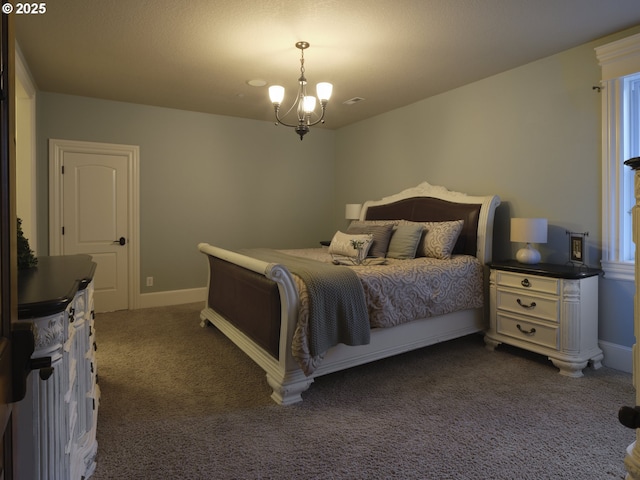 bedroom with an inviting chandelier and dark colored carpet