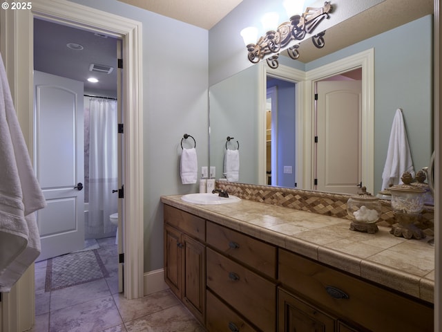 bathroom featuring vanity, toilet, and a chandelier