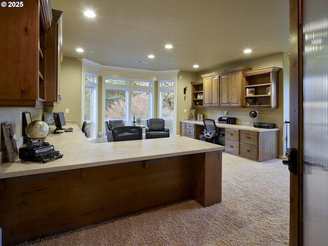 kitchen with light colored carpet, kitchen peninsula, and built in desk