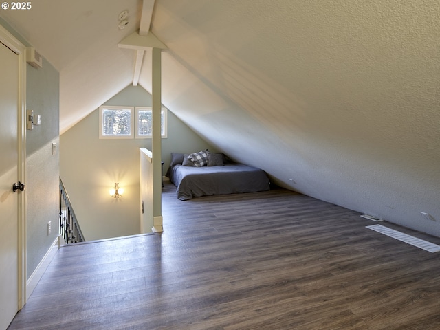 unfurnished bedroom featuring dark hardwood / wood-style flooring and vaulted ceiling with beams