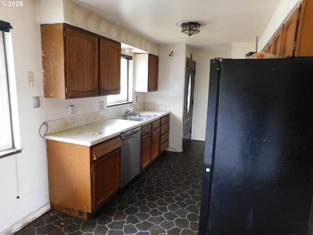 573 SW Harbor Pl, Warrenton, OR 97146 - kitchen with freestanding refrigerator, dishwasher, a sink, light countertops, and brown cabinetry