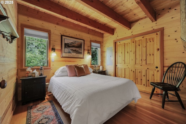 bedroom featuring wood finished floors, wood ceiling, beam ceiling, and wooden walls