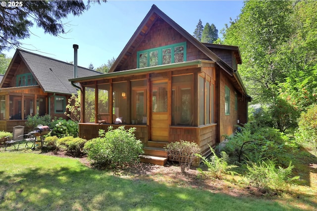 back of property featuring a yard and a sunroom