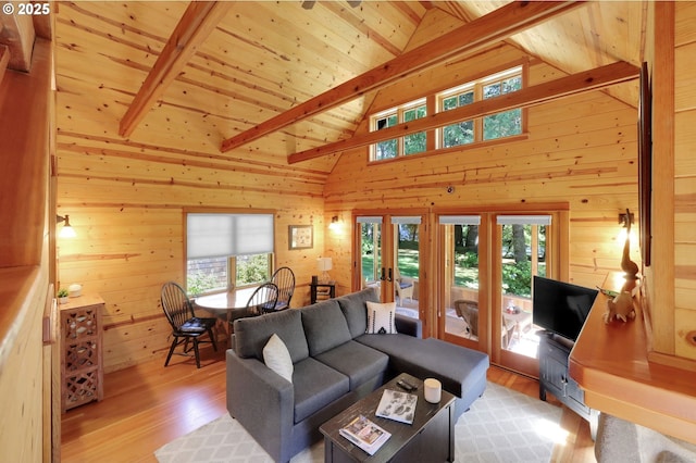 living area featuring beam ceiling, wood walls, french doors, wood finished floors, and wood ceiling