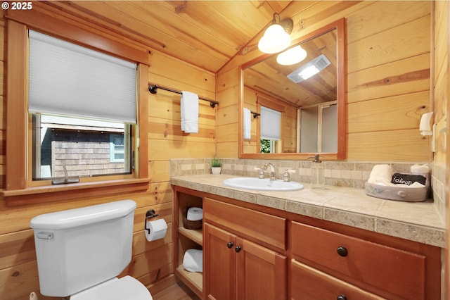 bathroom featuring toilet, wood walls, wooden ceiling, and vanity
