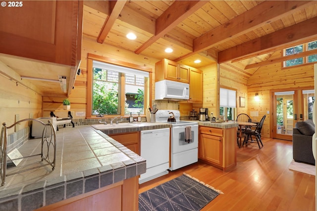 kitchen featuring tile countertops, wood ceiling, wood walls, and white appliances