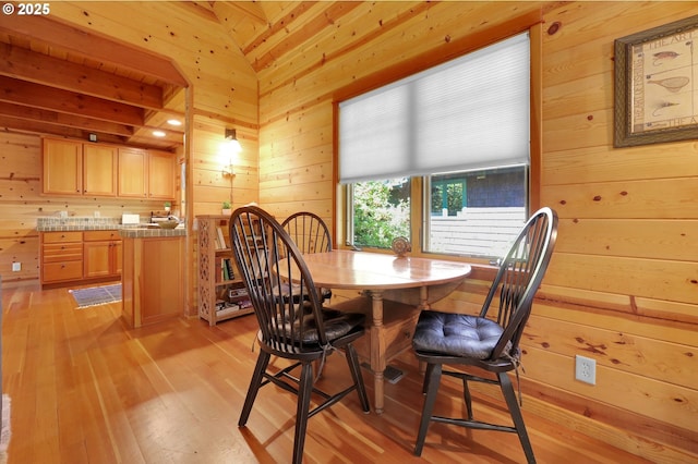 dining space featuring wooden walls and light wood-style flooring