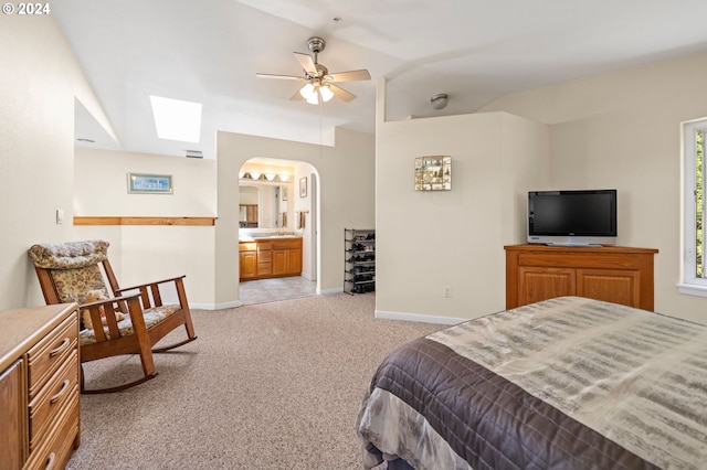 carpeted bedroom featuring ensuite bath and vaulted ceiling