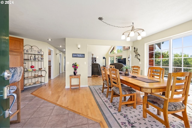 dining space with a healthy amount of sunlight, an inviting chandelier, and light hardwood / wood-style flooring