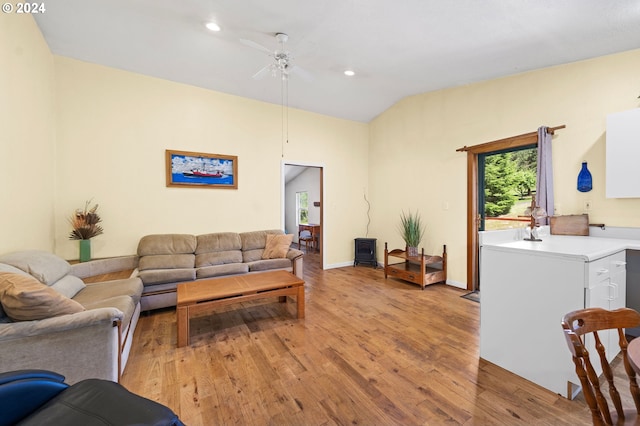 living room with lofted ceiling, ceiling fan, and light wood-type flooring