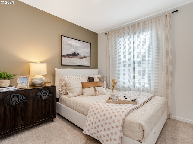 bedroom with light carpet and baseboards