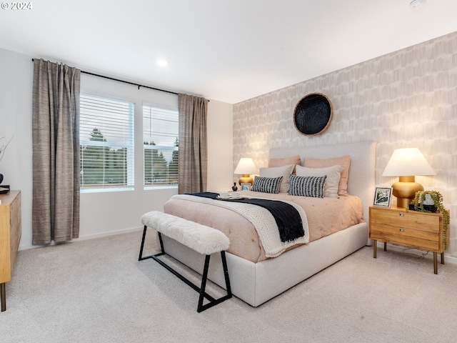 bedroom featuring light colored carpet and baseboards