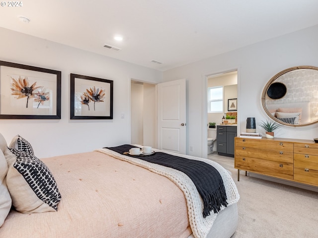 bedroom with light carpet, visible vents, and connected bathroom