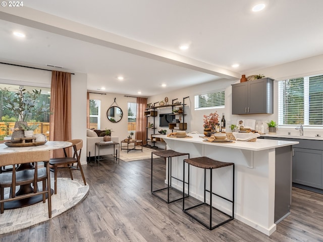 kitchen with a breakfast bar, a center island, gray cabinets, and light countertops