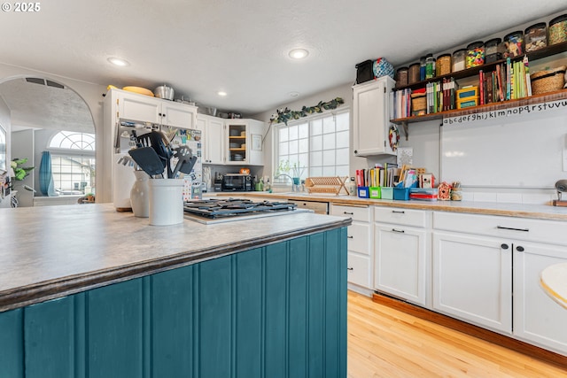 kitchen with white cabinetry, a wealth of natural light, stainless steel gas cooktop, and light hardwood / wood-style flooring