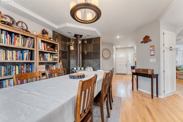 dining space with a textured ceiling and light hardwood / wood-style floors