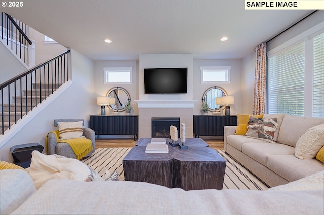 living room featuring light hardwood / wood-style flooring and a tile fireplace