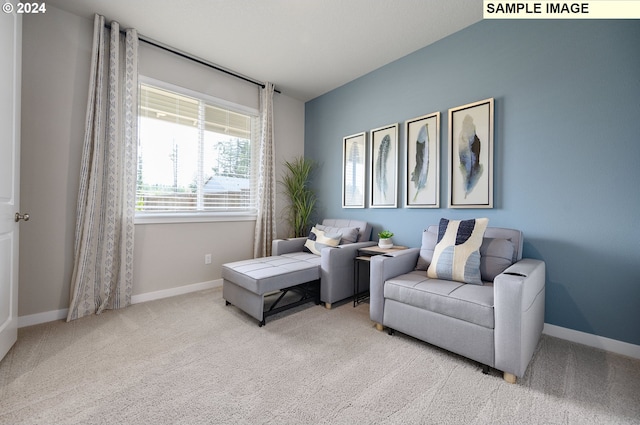 living area featuring light colored carpet and vaulted ceiling