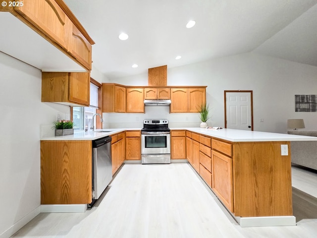 kitchen with stainless steel appliances, light countertops, under cabinet range hood, and a peninsula