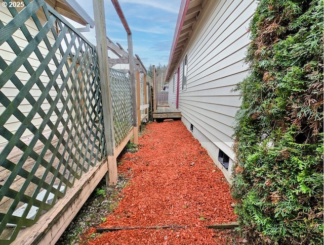 view of side of property featuring crawl space and fence