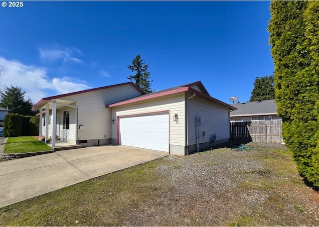 view of front of property with an attached garage, fence, and concrete driveway