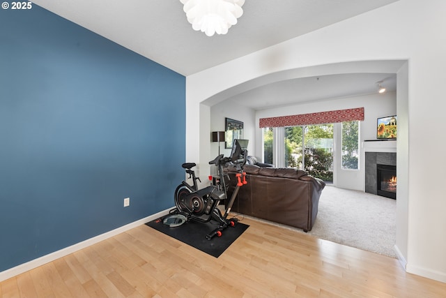 15416 SW Mallard Dr Unit 102, Beaverton, OR 97007 - exercise room with arched walkways, wood finished floors, a tile fireplace, and baseboards
